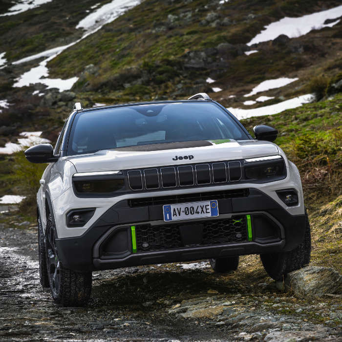 Jeep Avenger 4xe Hybrid білого кольору на слизькій дорозі в горах