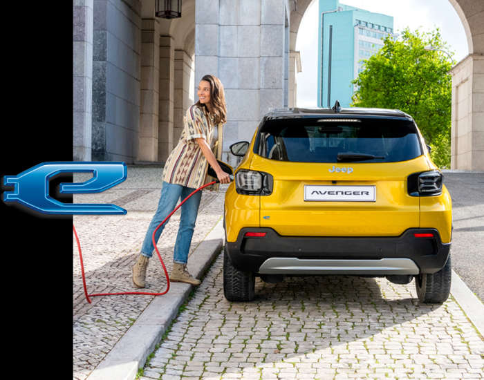 Електромобіль Jeep Avenger, дівчина встромляє штекер у зарядне гніздо