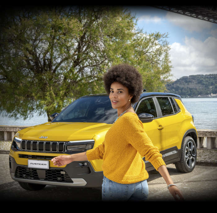 Молода дівчина перед Jeep Avenger на набережній у місті