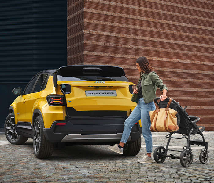 Jeep Avenger, дівчина проводить ногою піб заднім бампером, щоб відкрити багажник